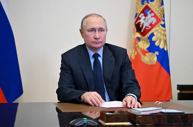 La Russie accuse ce pays de propager la variole du singe... Vladimir Poutine assis à une table avec drapeaux russes en arrière-plan.