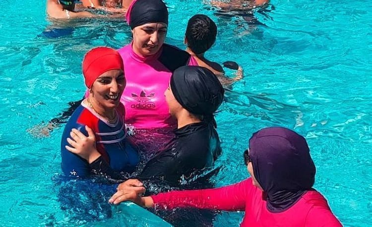 Le ministre français de l'Intérieur poursuit sa guerre contre le burkini Femmes en burkini discutant dans une piscine ensoleillée.