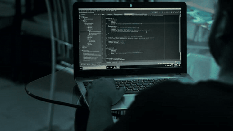 Hacker travaillant sur un code informatique en noir et blanc.