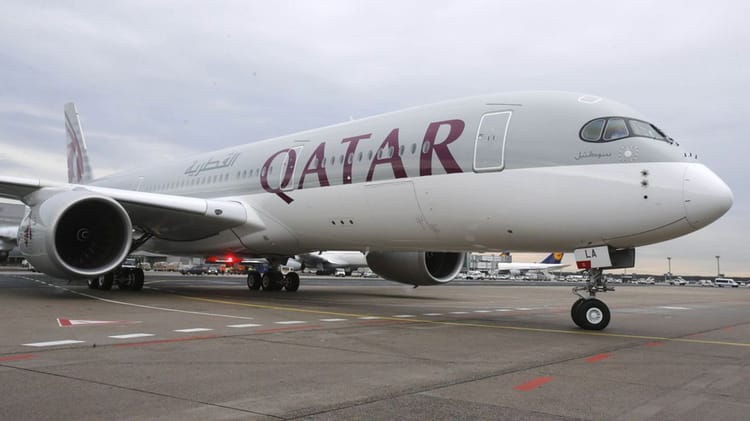 Avion Qatar Airways stationné à l'aéroport avec vue sur le tarmac.