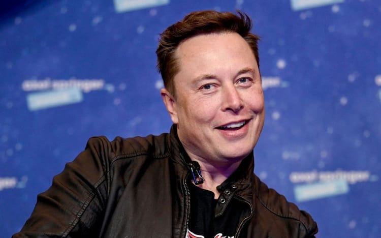Elon Musk souriant lors d'une conférence ou d'un événement public.