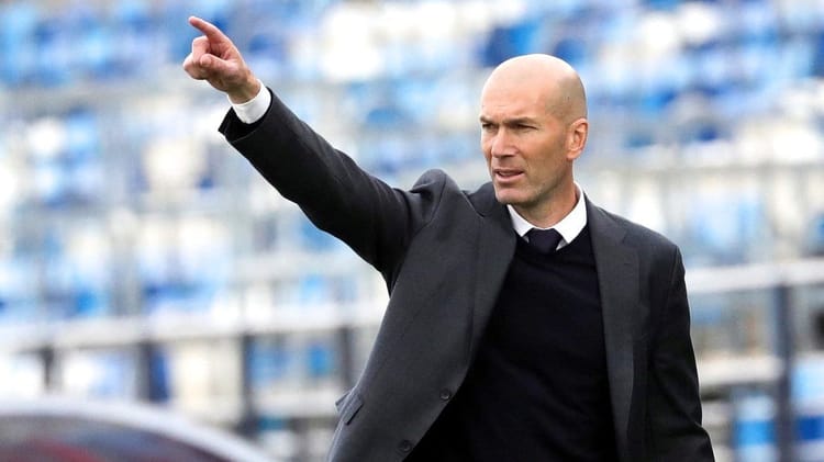 Zidane, entraîneur, pointant du doigt lors d'un match de football.