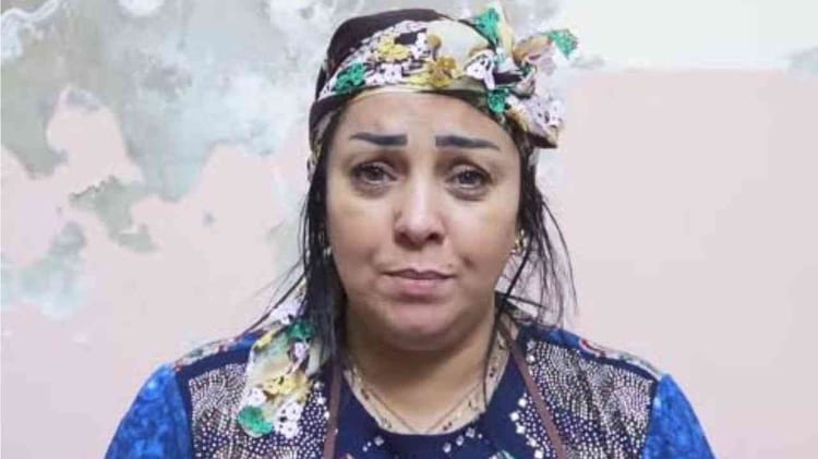 Femme avec un visage inquiet et un foulard coloré sur la tête.