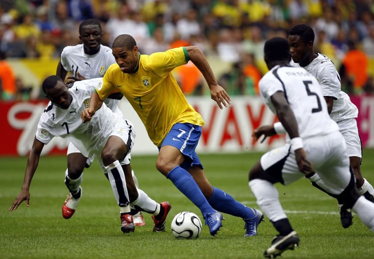 Joueur brésilien en action contre des défenseurs ghanéens lors de la Coupe du Monde 2006.