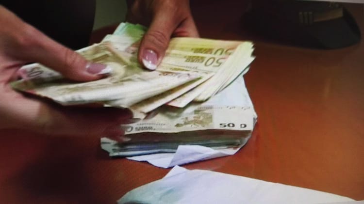 Main tenant des billets de banque en dinar algérien.