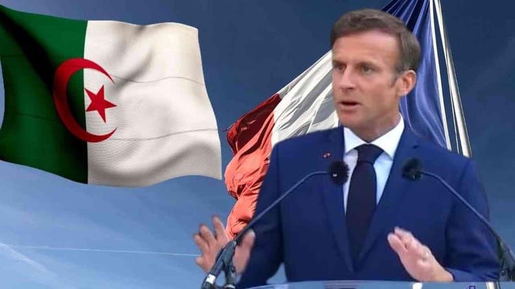 Emmanuel Macron lors d'une allocution avec drapeaux algérien et français en arrière-plan.