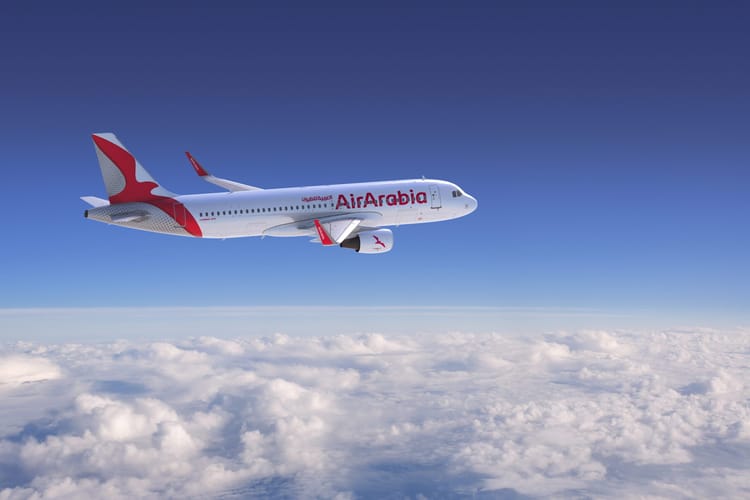 Avion Air Arabia survolant les nuages dans un ciel clair.