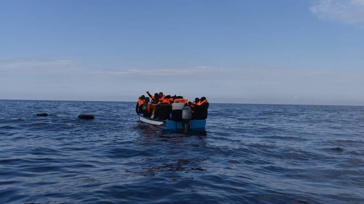 Groupe de migrants en mer, bateau de fortune au large d'Alger.