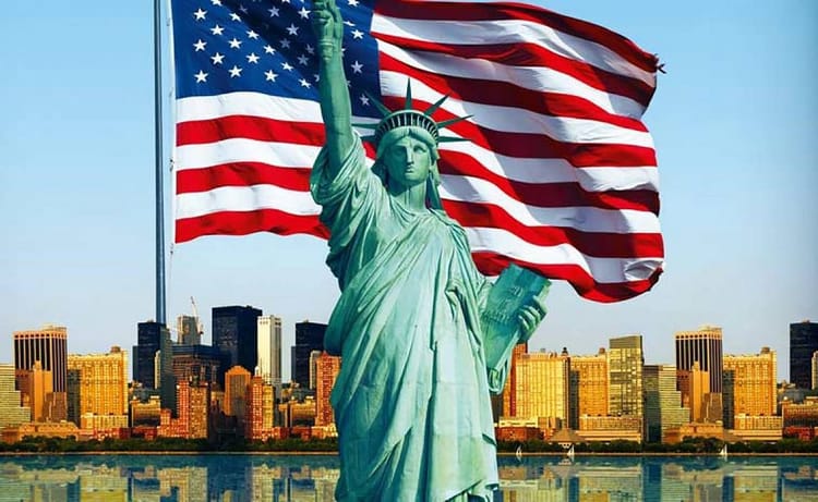 Statue de la Liberté avec drapeau américain et skyline de New York.