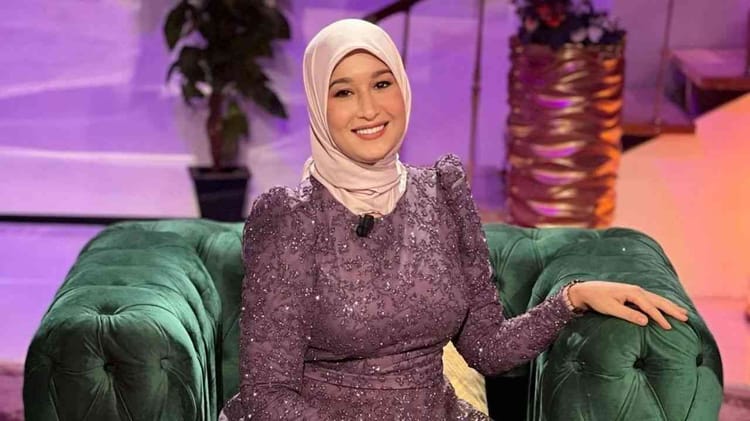 Maya Redjil souriante en tenue élégante lors d'une interview.
