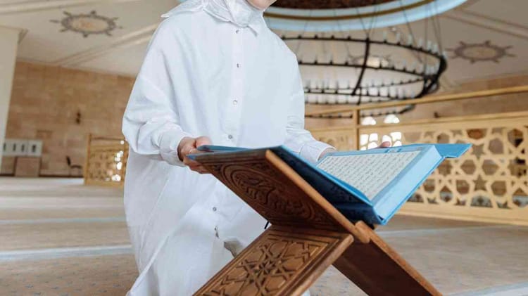 Mawlid Nabawi 2022 Algérie : la date de célébration enfin révélée Personne lisant le Coran dans une mosquée, ambiance religieuse.