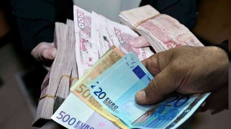Main tenant des billets de banque en euros et dinar algérien.