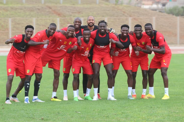 Groupe de joueurs de football en entraînement sur le terrain.