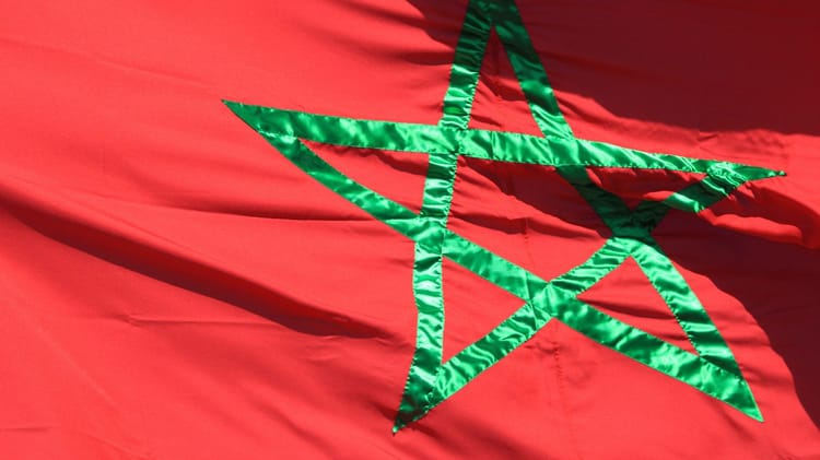 Drapeau du Maroc avec étoile verte sur fond rouge.