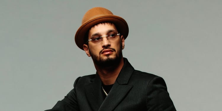 Soolking, artiste algérien, en France, portant un chapeau et des lunettes.