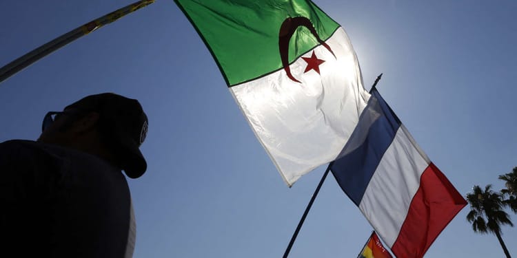 Drapeaux algérien et français flottant au vent en plein air.