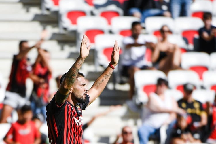 Divers : Le cadeau de l'OGC Nice à Andy Delort Andy Delort lors d'un match de football avec le public en arrière-plan.