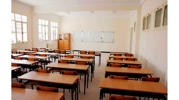 Salle de classe vide avec des bureaux et des chaises en Algérie.