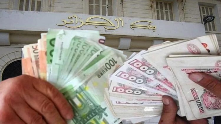 Main tenant des billets de banque algériens de différentes coupures.