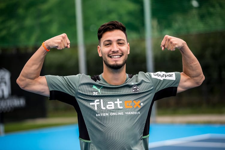 Manchester United, Barcelone... Bensebaini attire les convoitises Bensebaini souriant en maillot de football lors d'un entraînement.