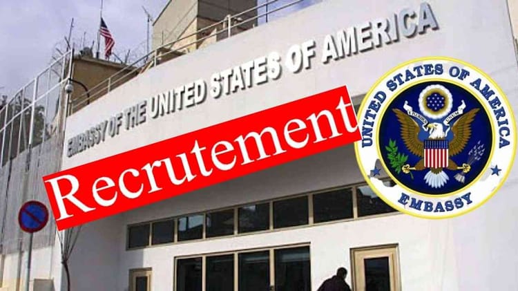 Bâtiment de l'ambassade des États-Unis en Algérie avec logo et panneau de recrutement.