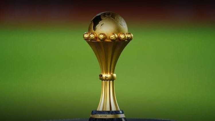 Trophée de la CAN 2025 en or avec globe terrestre.