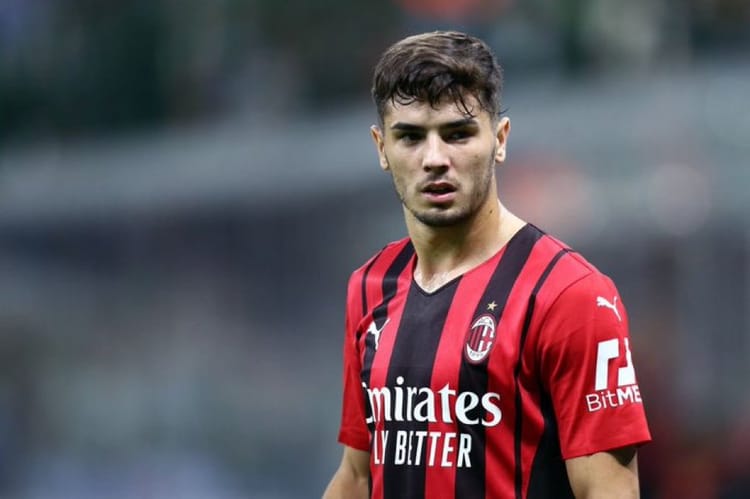 Jeune joueur de football en maillot AC Milan sur le terrain.