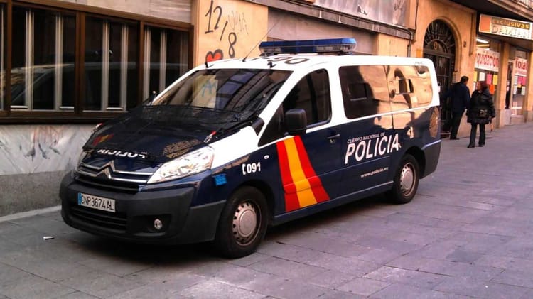 Véhicule de police espagnol sur une rue urbaine.
