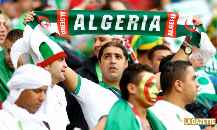 Supporters algériens avec drapeau et écharpe lors du match.