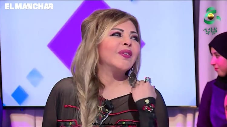 Appel à l’aide : Exclue des médias arabes, Fella Ababsa fait recours à un ancien ministre Fella Ababsa en pleine interview avec un fond coloré.