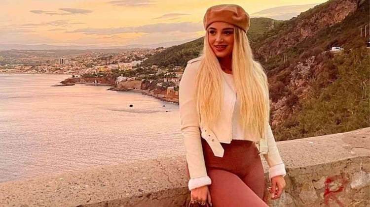 Numidia Lezoul en Algérie ou en France ? Voici la réponse Jeune femme blonde souriante en tenue décontractée au bord de la mer.