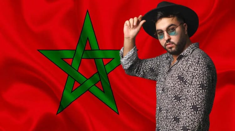 Homme avec chapeau et lunettes devant drapeau du Maroc.