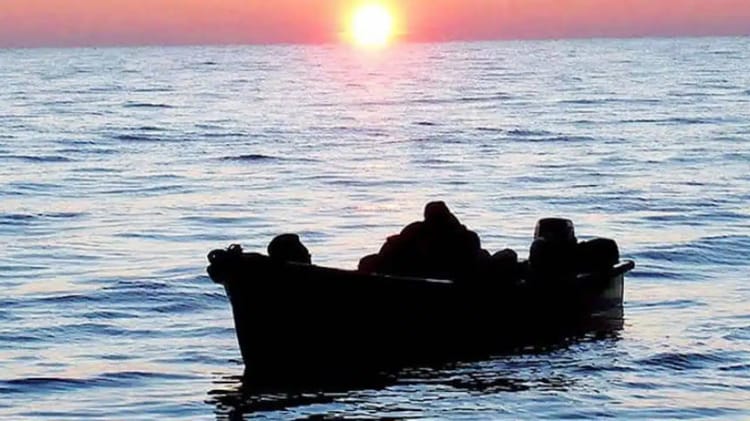 Bateau en mer au coucher de soleil, migration clandestine.