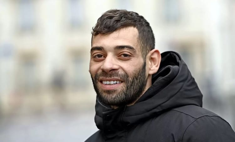 France : après avoir sauvé une femme séquestrée, un Algérien risque l’expulsion Homme souriant portant un manteau noir en extérieur.