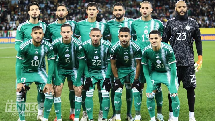 Groupe de joueurs algériens en tenue de match sur le terrain.