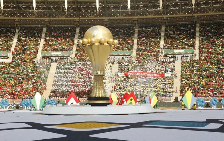 Trophée de la CAN 2025 dans un stade rempli de spectateurs.