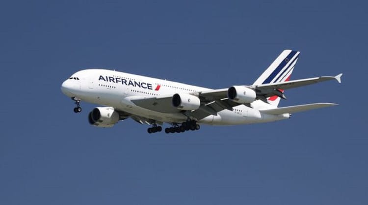 Avion Air France en vol dans le ciel bleu clair.