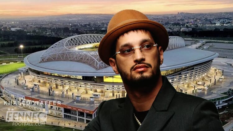 Portrait d'un homme avec chapeau devant le stade de Baraki au coucher du soleil.