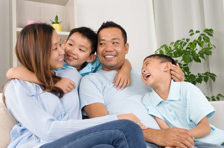 France : Voici comment faire une demande de regroupement familial Famille souriante partageant un moment de bonheur à la maison.