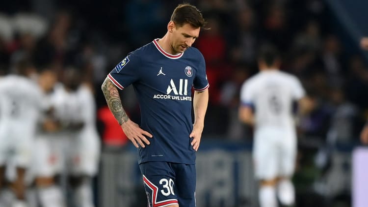 Lionel Messi en maillot du PSG sur le terrain de football.