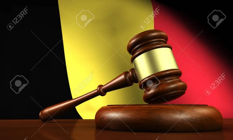 Gavel en bois avec drapeau belge en arrière-plan.