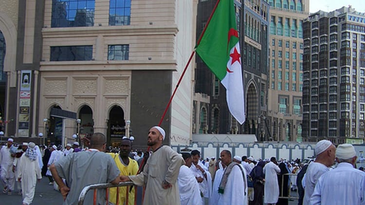 Pèlerins algériens avec drapeau national à La Mecque.