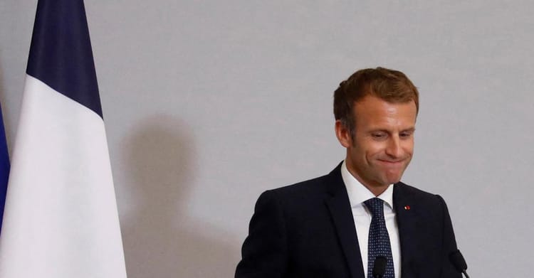 Emmanuel Macron souriant lors d'une conférence officielle.