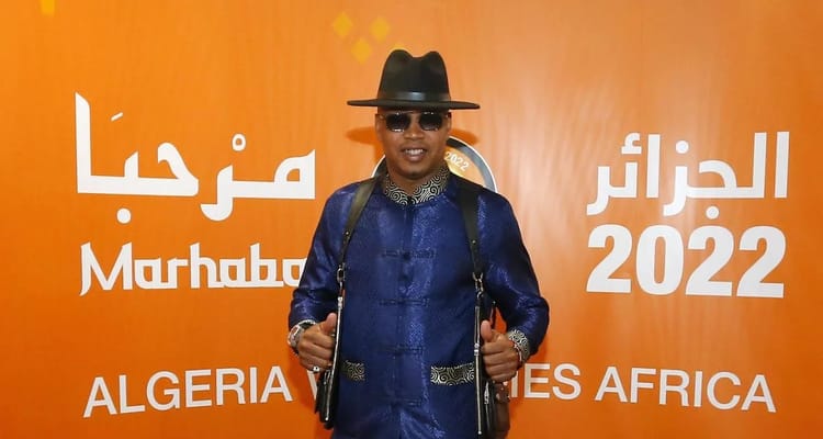 CHAN 2022 : « l’Algérie peut organiser une Coupe du Monde », selon El-Hadji Diouf Homme portant un costume bleu, chapeau noir et lunettes de soleil lors de l'événement Marhaba 2022.
