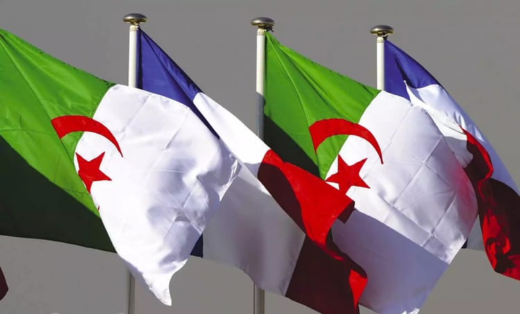 Drapeaux algérien et français flottant au vent.