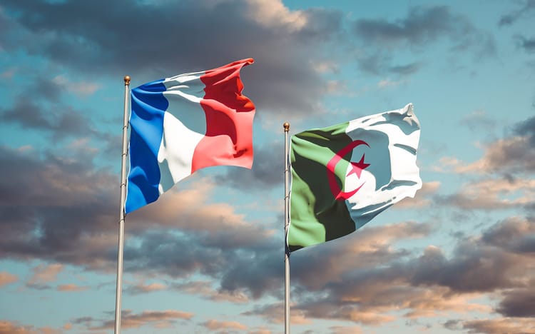 Drapeaux de la France et de l'Algérie flottant dans le ciel.