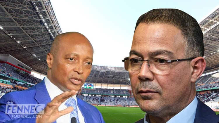 Fouzi Lekjaa et un officiel lors d'un match de football au stade.