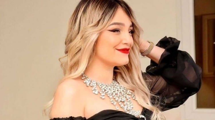 Numidia Lezoul souriante avec maquillage sophistiqué et bijoux brillants.