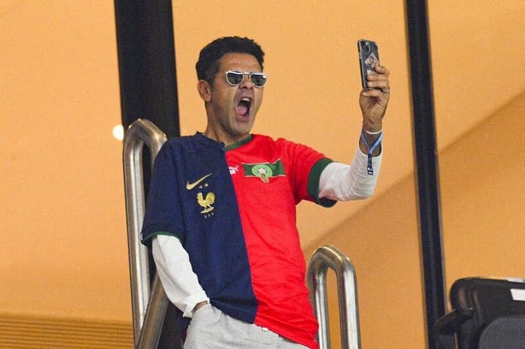 Le drapeau Algérien est insensé : Un ami à Jamel Debbouze crée la controverse Homme portant un t-shirt avec drapeau algérien et français, prenant une photo avec son téléphone.