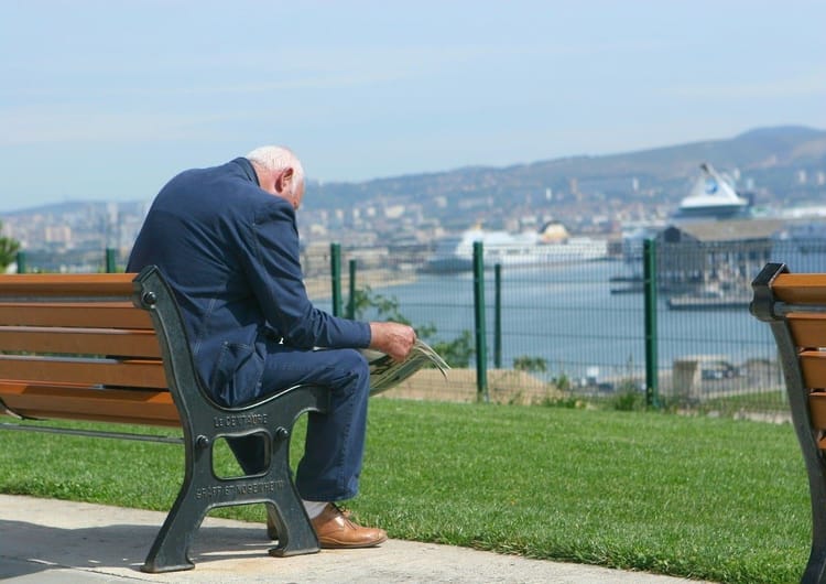 Retraites en France : Augmentation des pensions à partir de... Homme retraité regardant la mer depuis un parc en ville.
